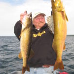 Ted Peck holding up two massive walleyes